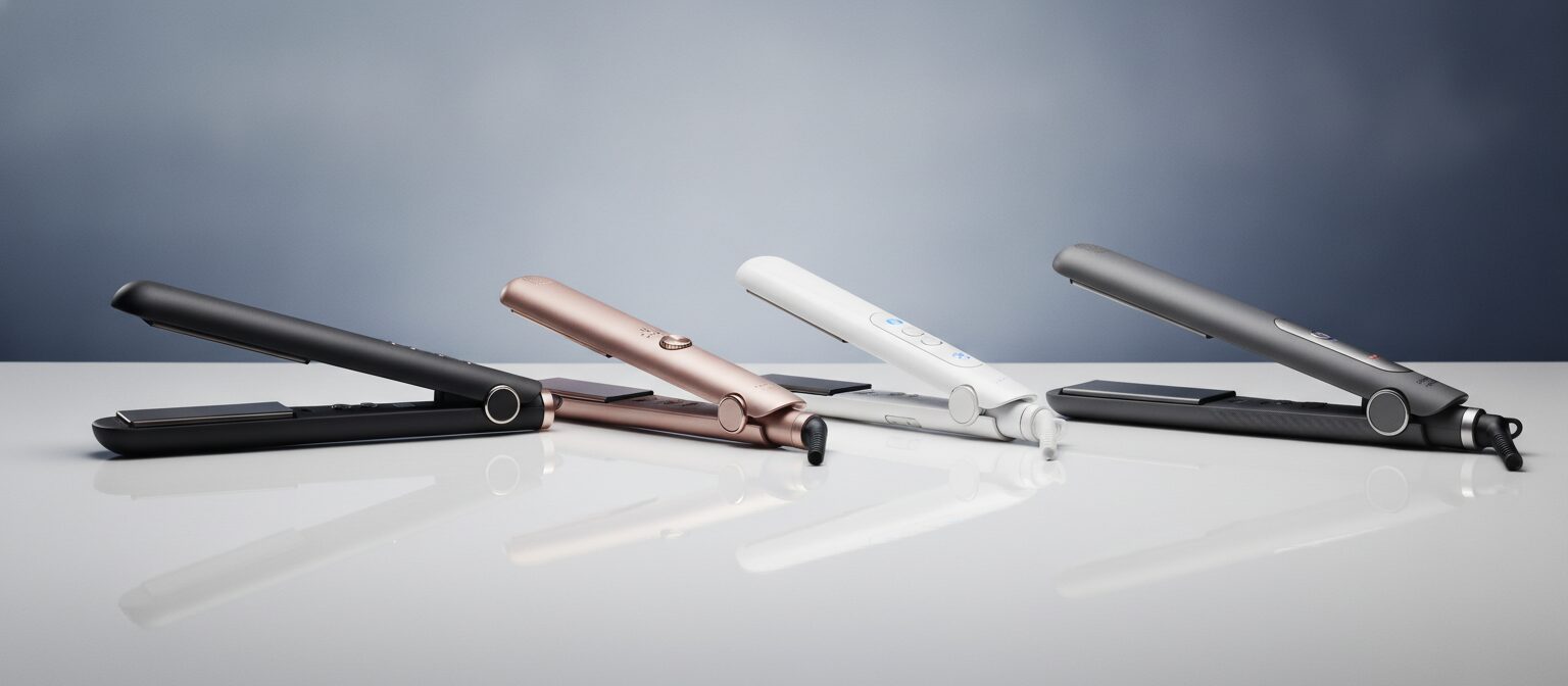 Hair straightening flat irons lined up for comparison on a pale surface