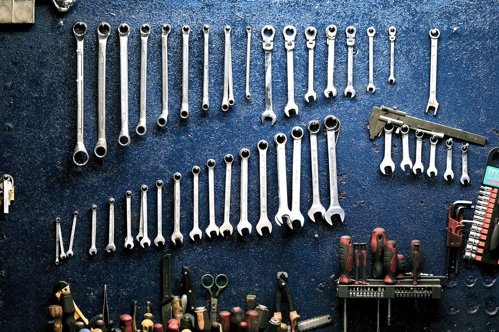 Organized garage pegboard wall holding hand tools like screwdrivers and pliers
