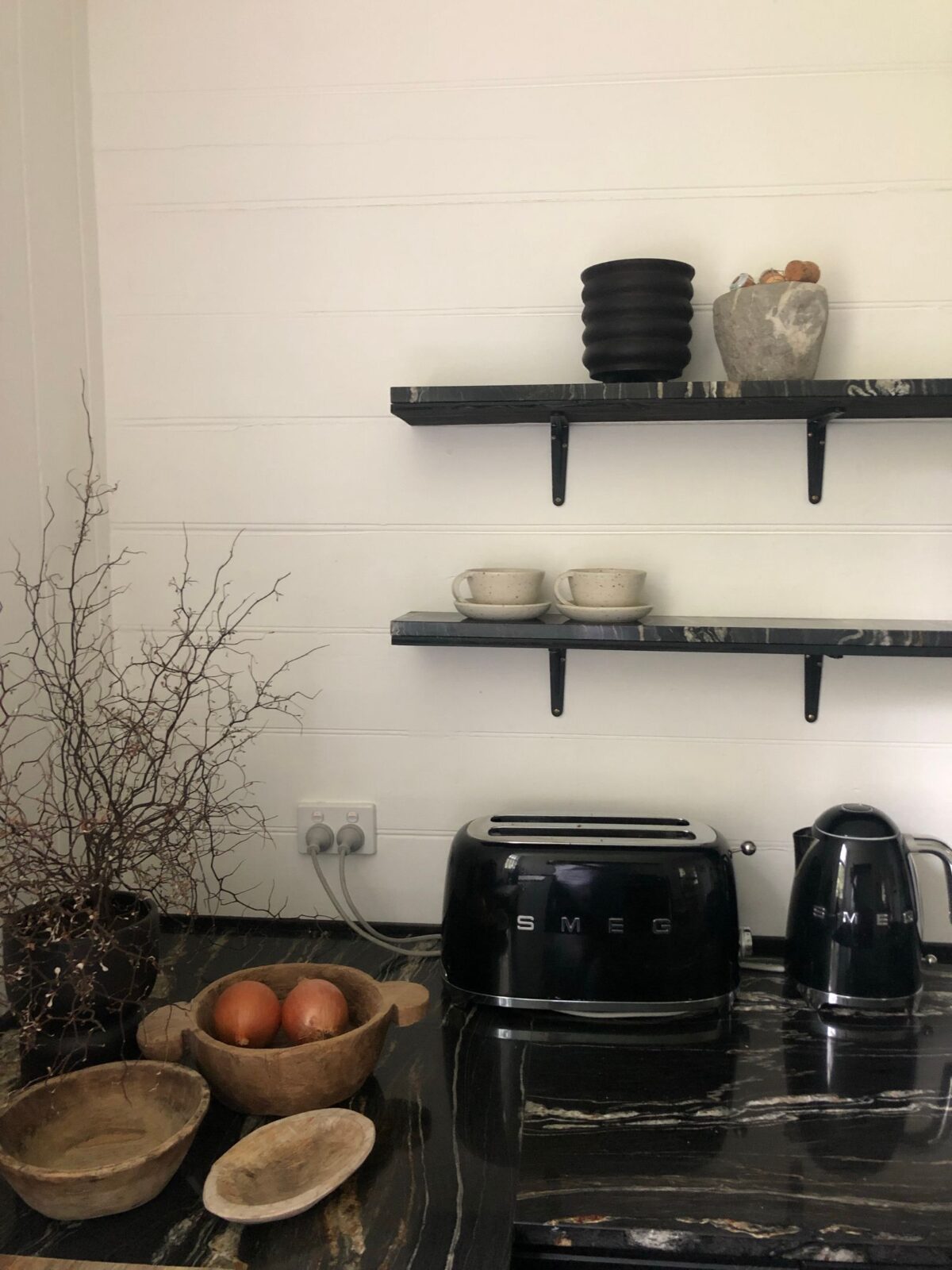 Modern kitchen appliances including a kettle on a marble countertop