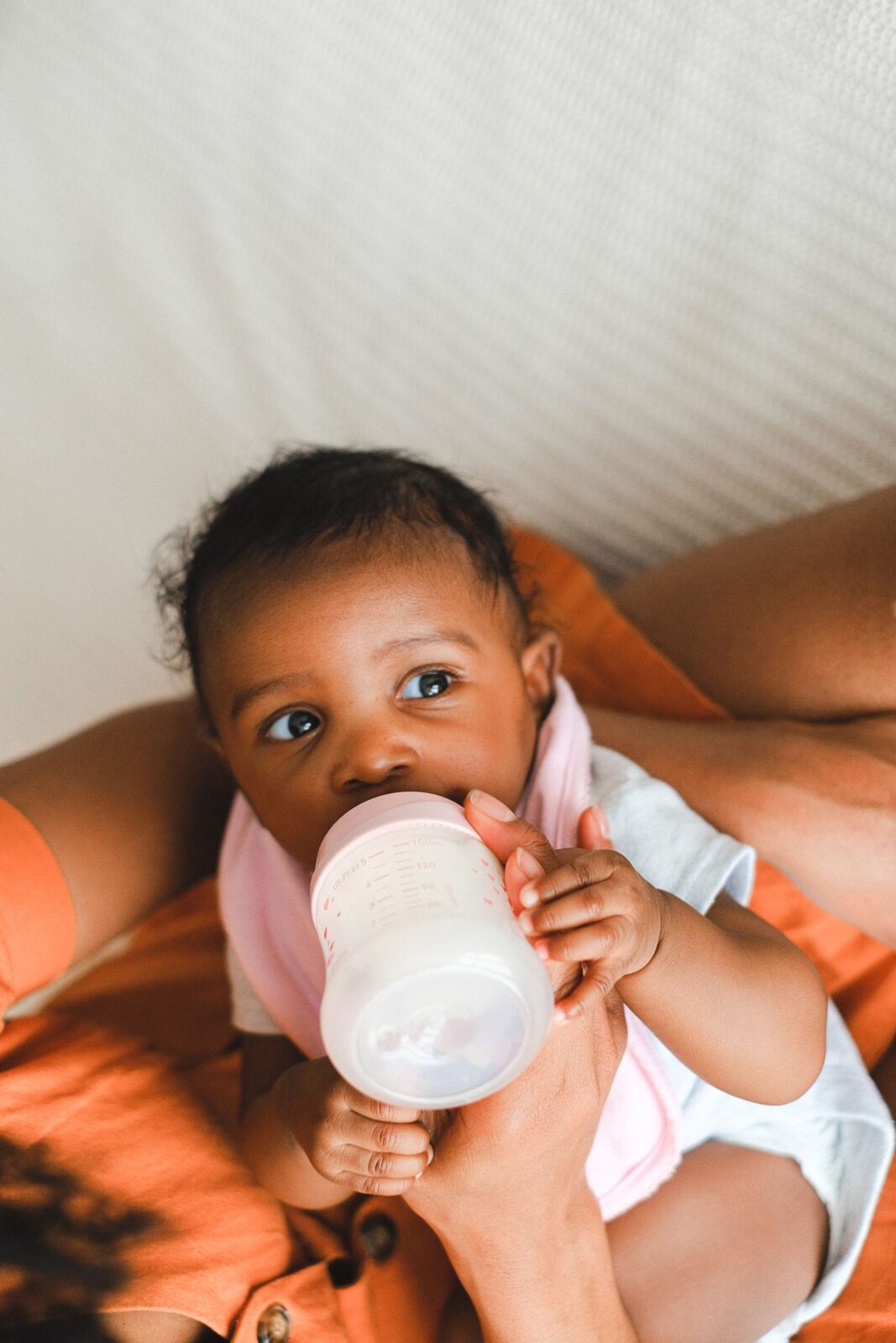 Baby drinking warm milk from a bottle