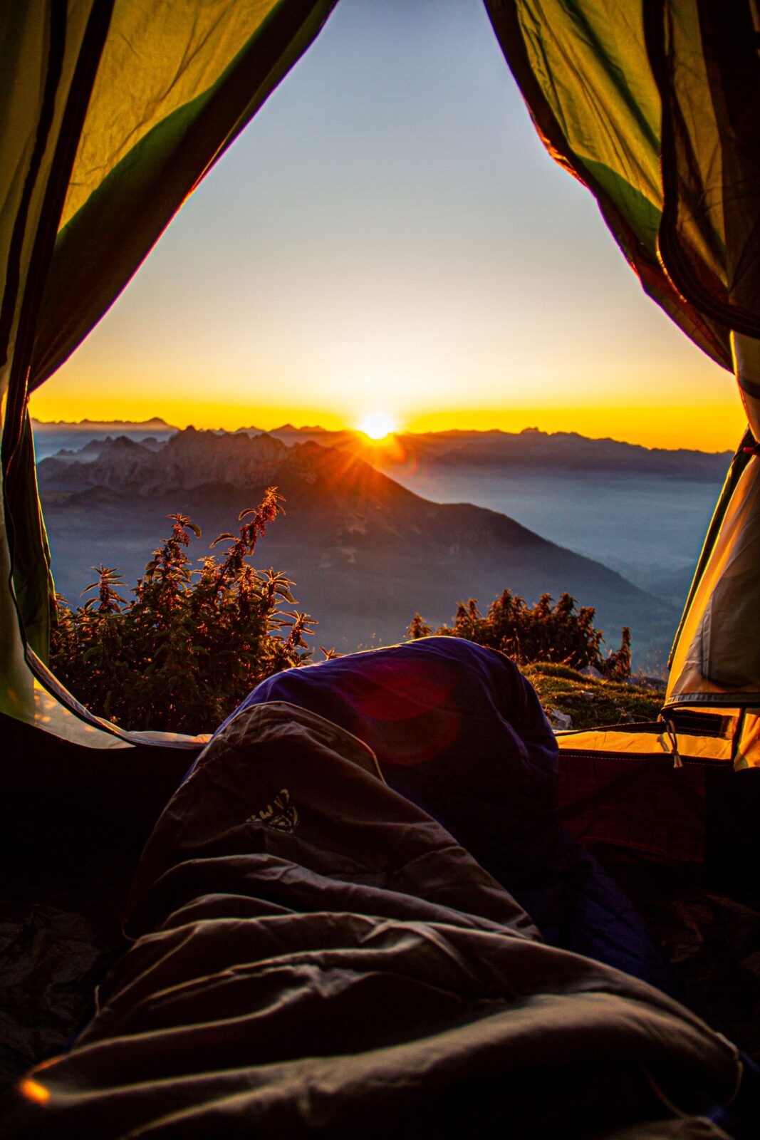 Tent pitched in the mountains at sunrise in exposed terrain