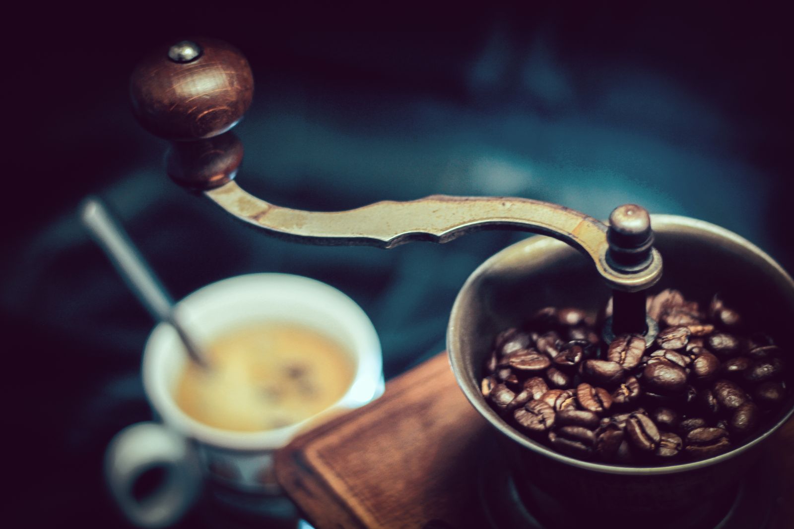 Coffee grinder next to whole beans, used to dial in grind size for espresso