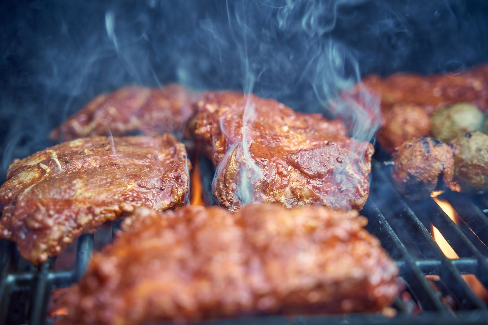 Steak searing with grill marks over direct flame on a pellet grill