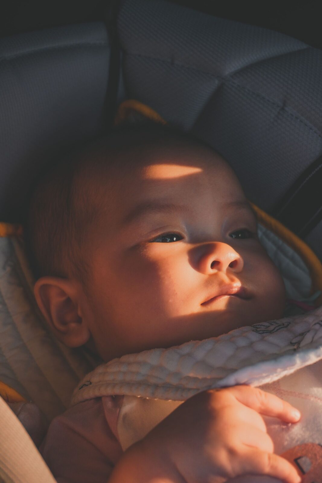 A newborn sleeping in a portable infant car seat carrier