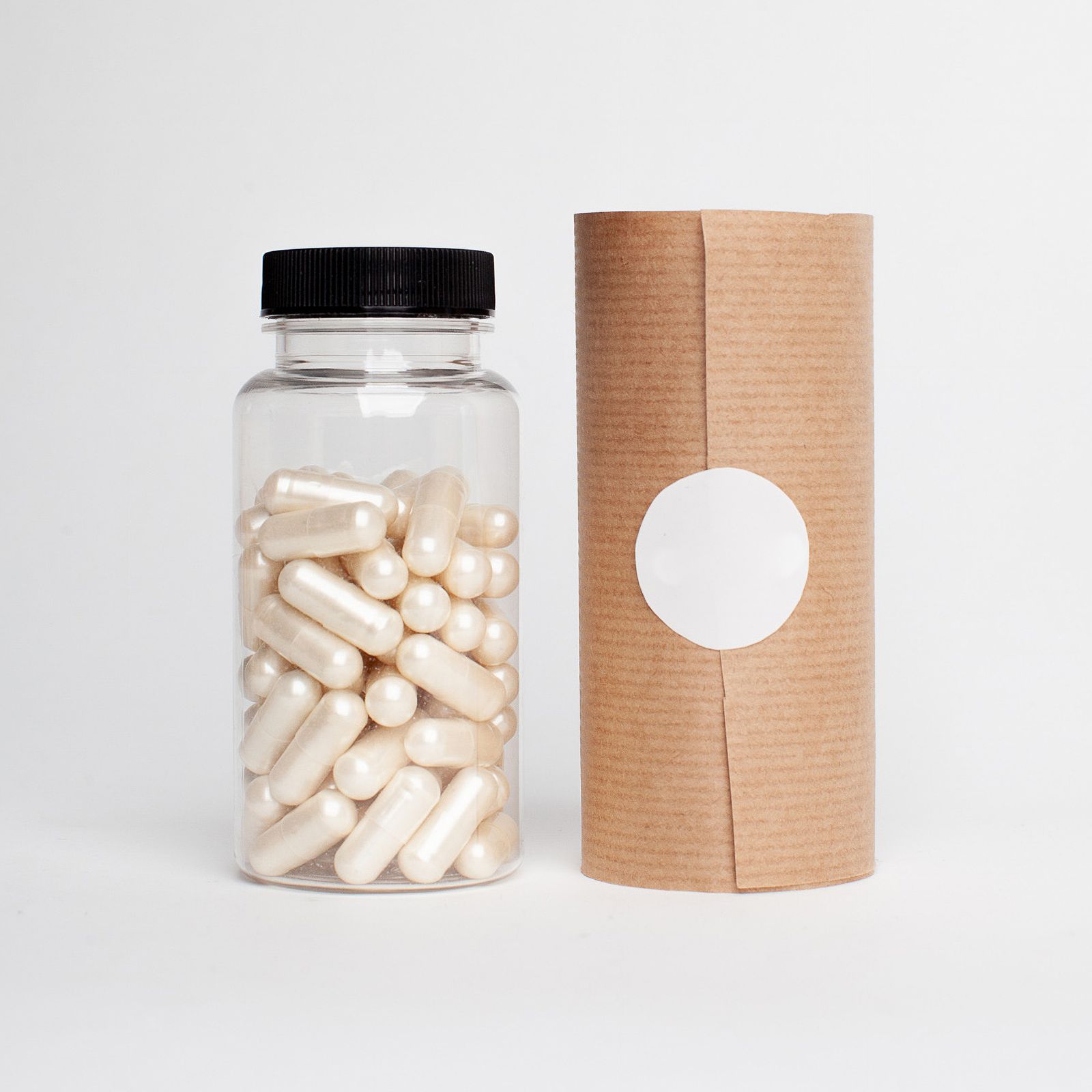 White supplement capsules spilling from a plastic bottle