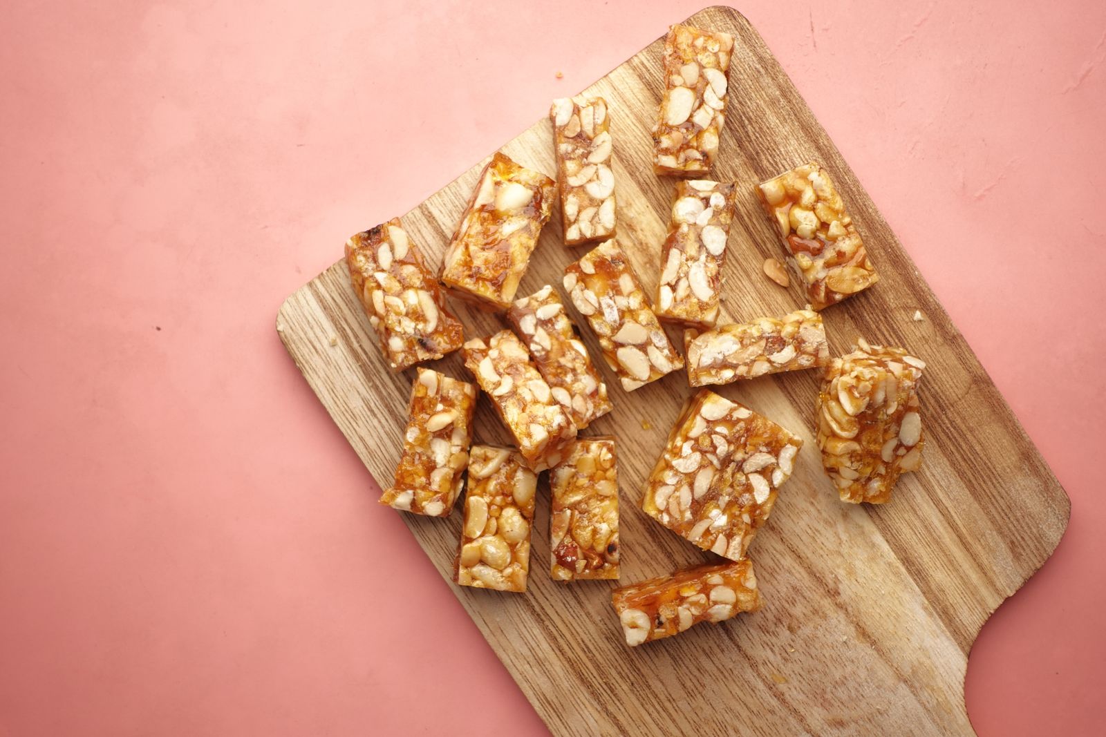 Homemade-style protein bars cut into pieces on a wooden cutting board