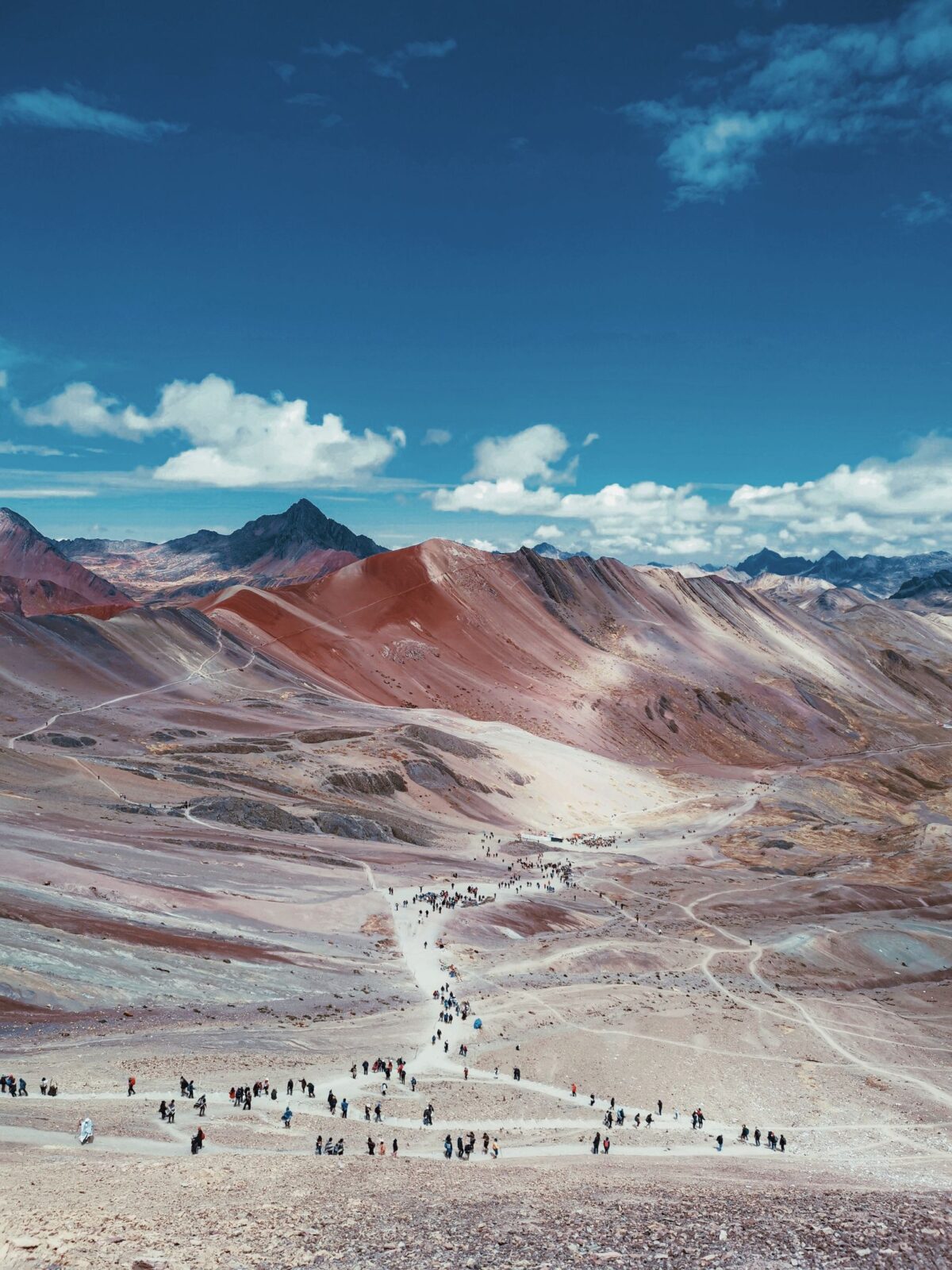 Hikers walking on a maintained mountain trail under a blue sky