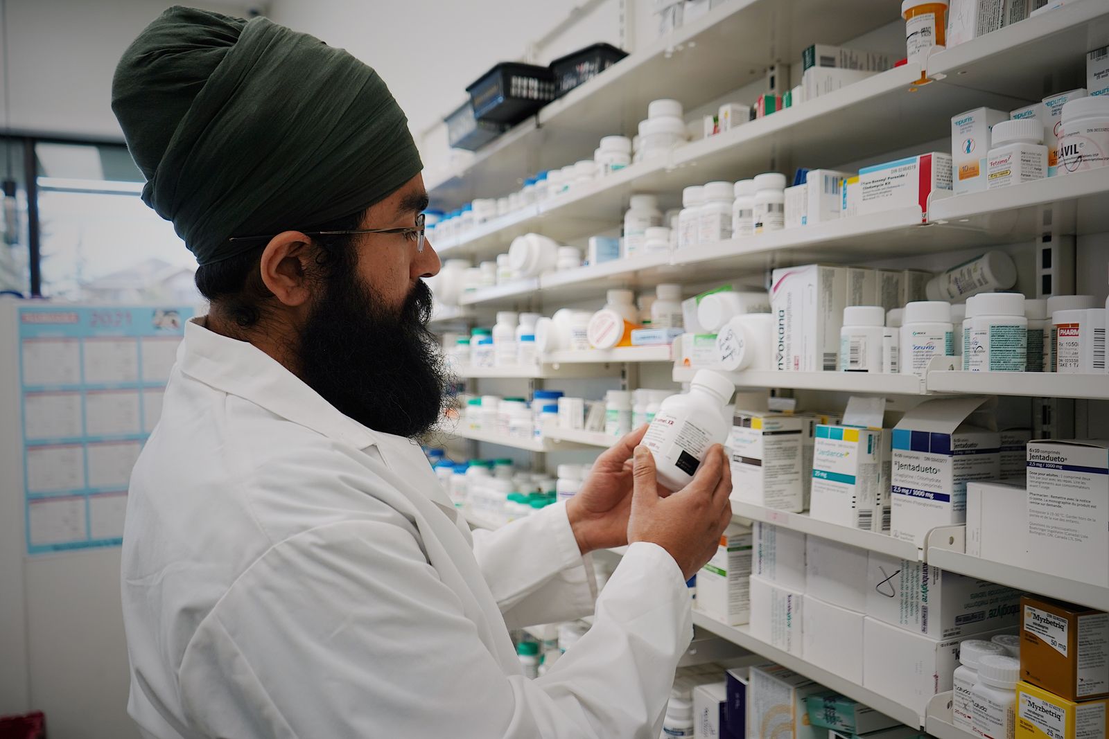 A pharmacist preparing medication at a compounding pharmacy counter