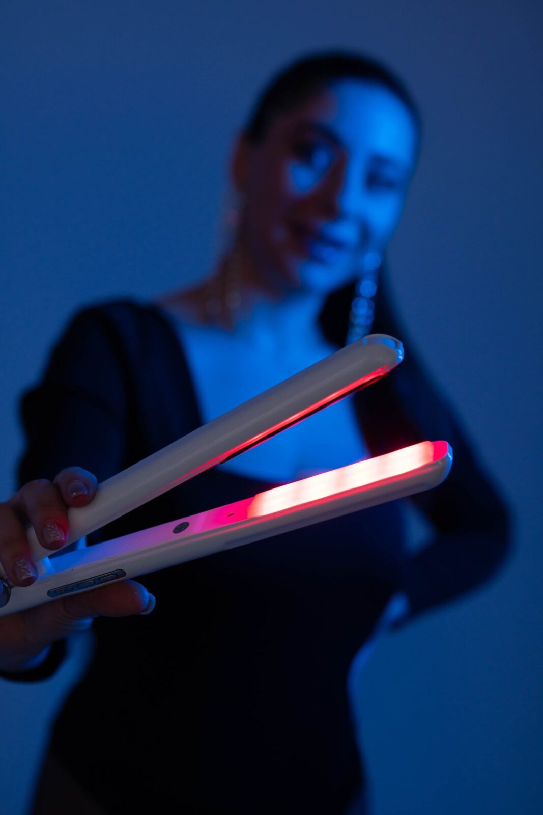 A woman holding a hair straightening tool