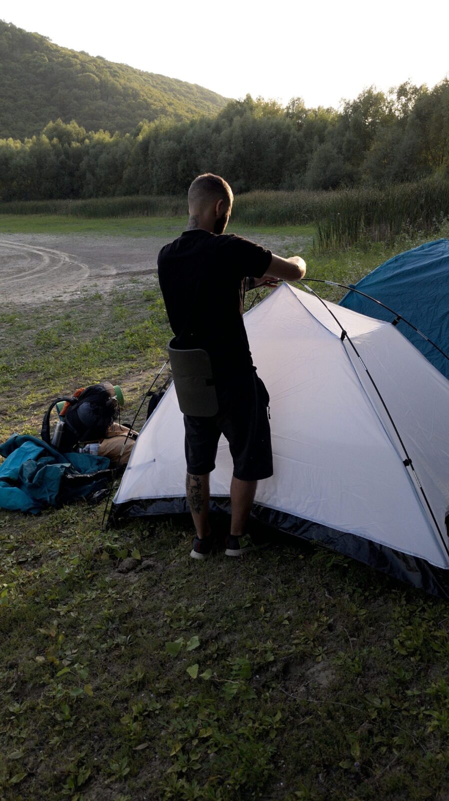 Man setting up a camping tent at a campsite