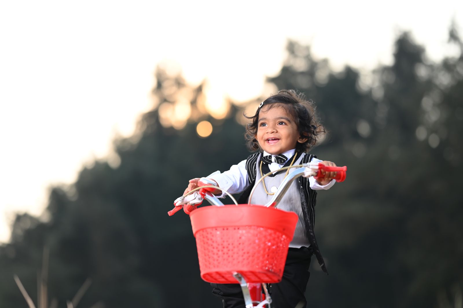 Preschool child pedaling a small bike in a park wearing a helmet