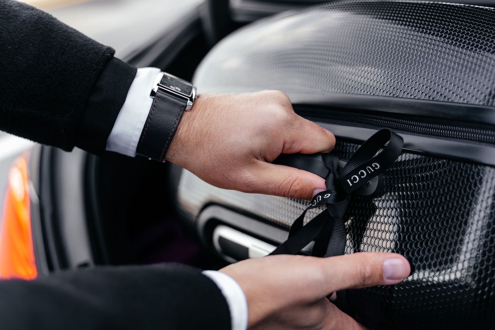 A person loading a suitcase into a car for travel