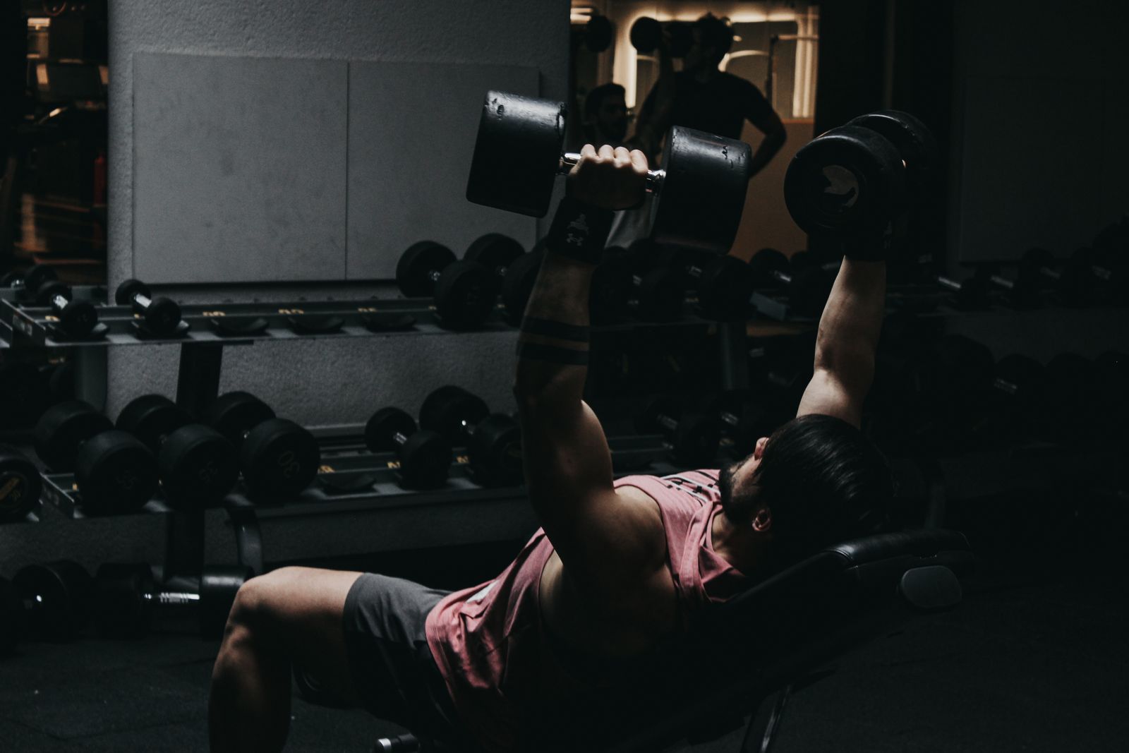 Person doing an incline dumbbell press on an adjustable bench