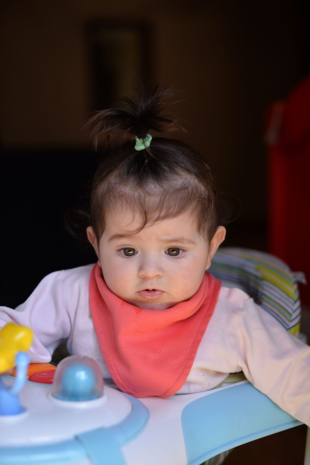 A baby relaxing in a lightweight bouncer seat