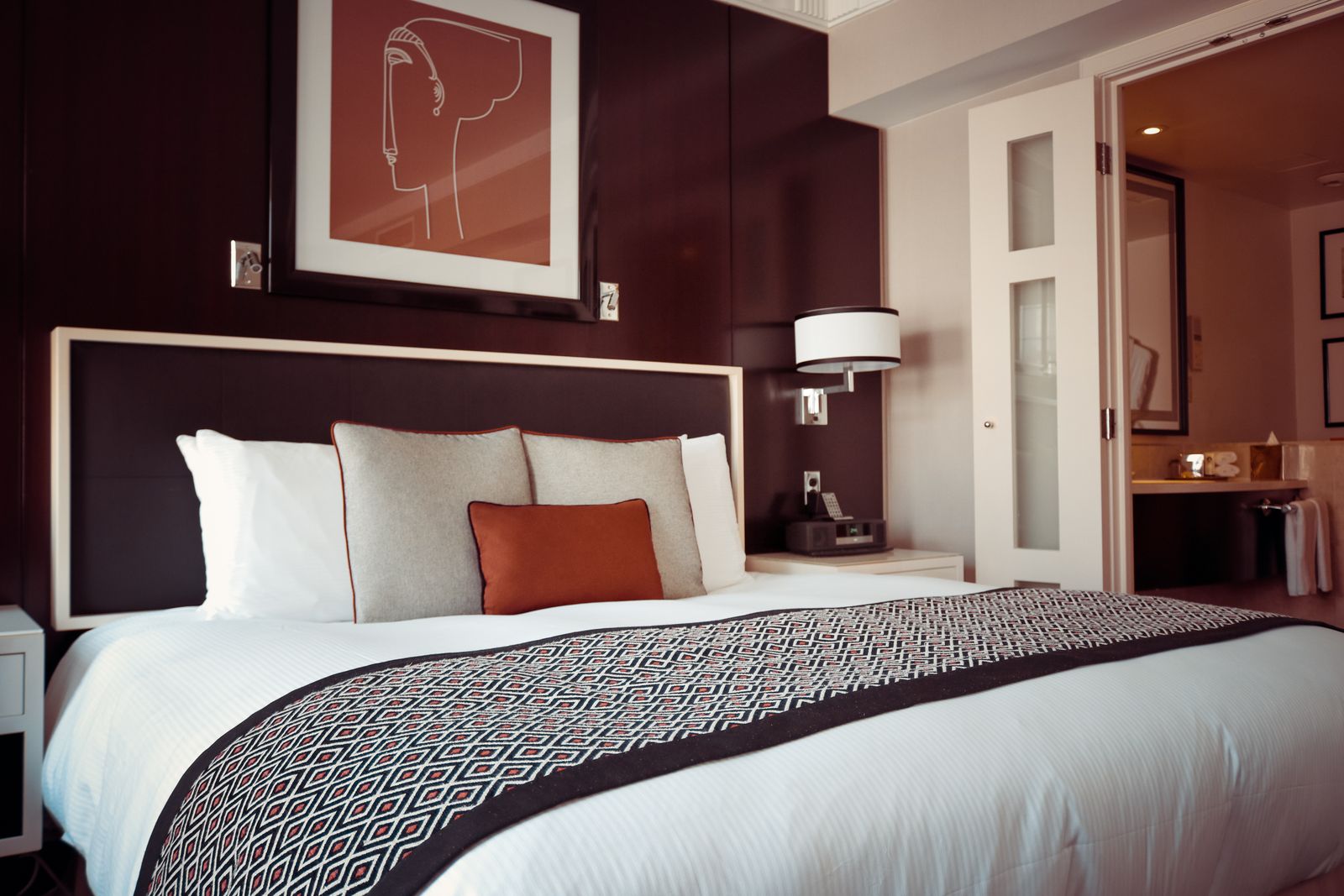 Neatly made bed in a bright guest bedroom