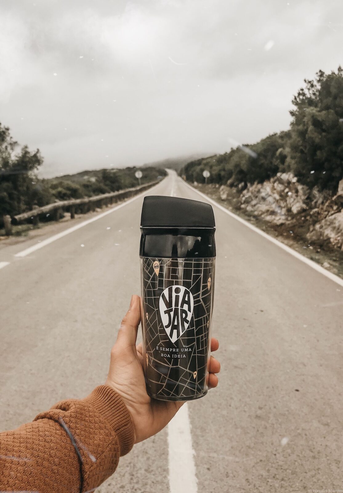 A person holding an insulated stainless steel tumbler