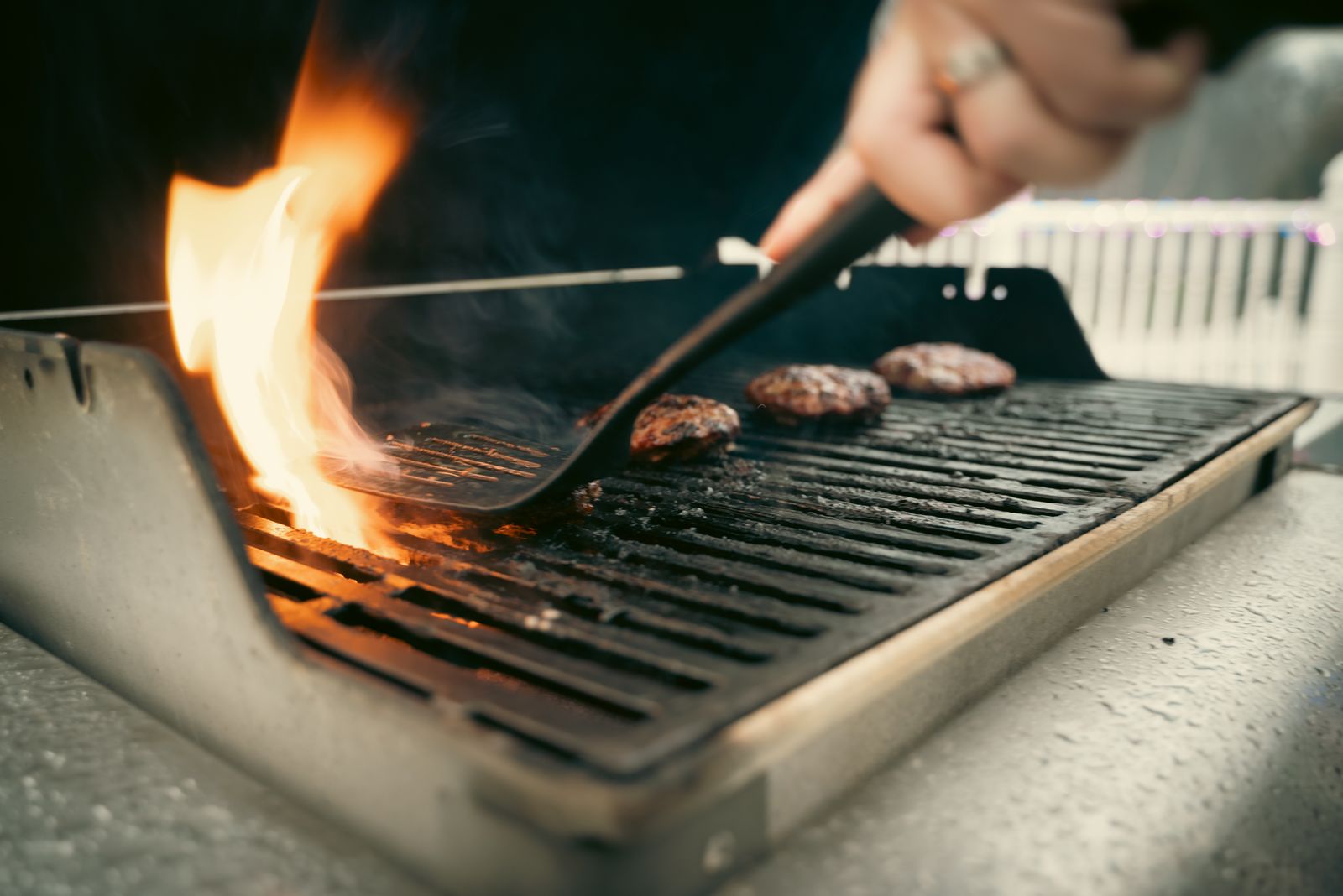 Burgers and vegetables searing on grill grates with grill marks