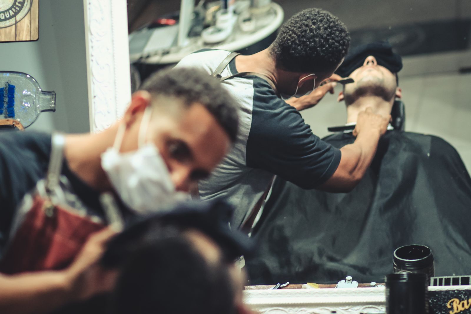 A man grooming his beard in front of a mirror