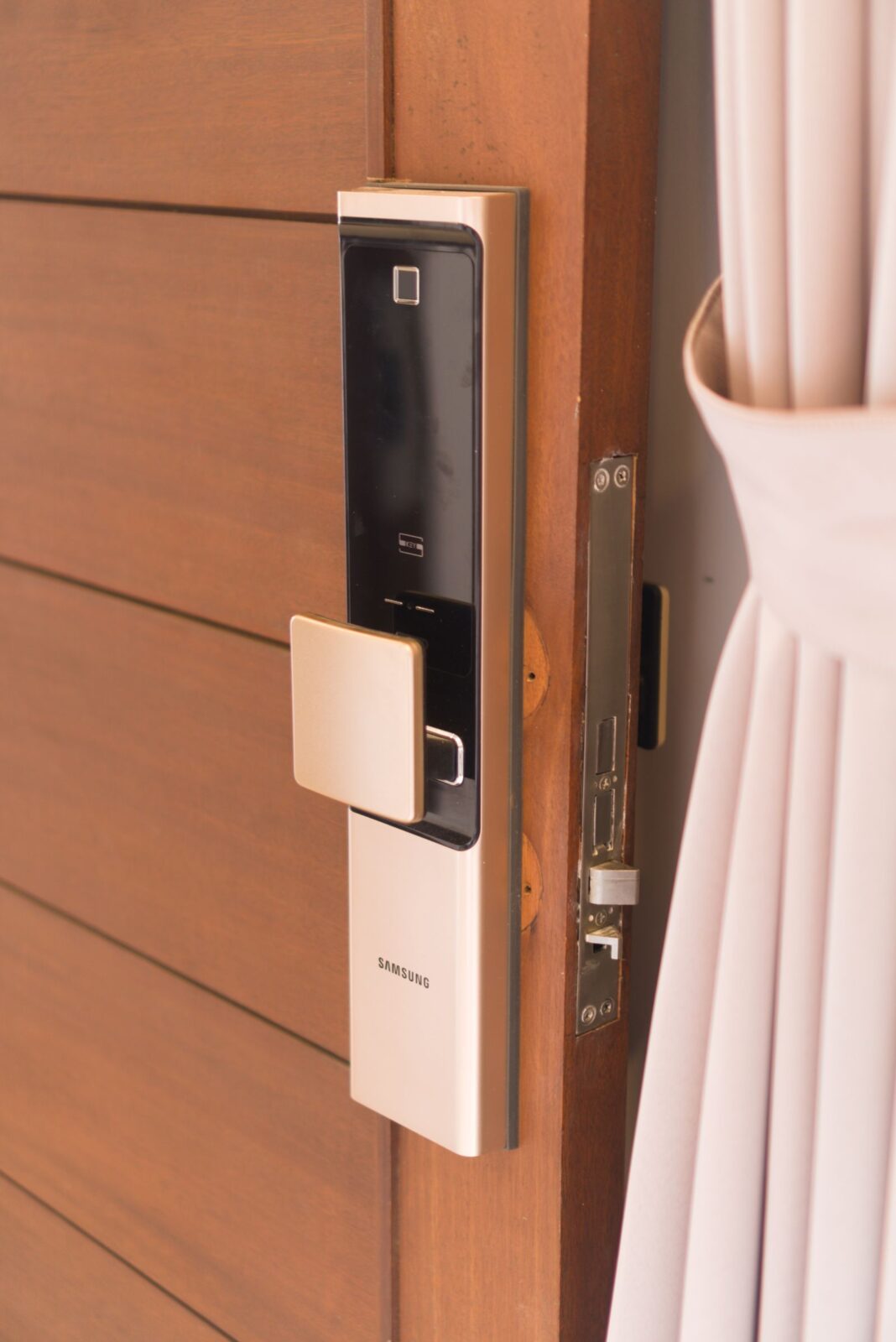 Modern smart lock with keypad mounted on a wooden front door