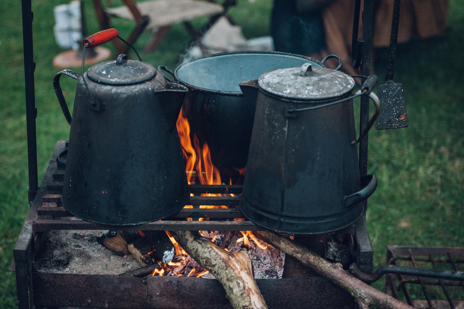 Pots cooking over an open flame at a campsite