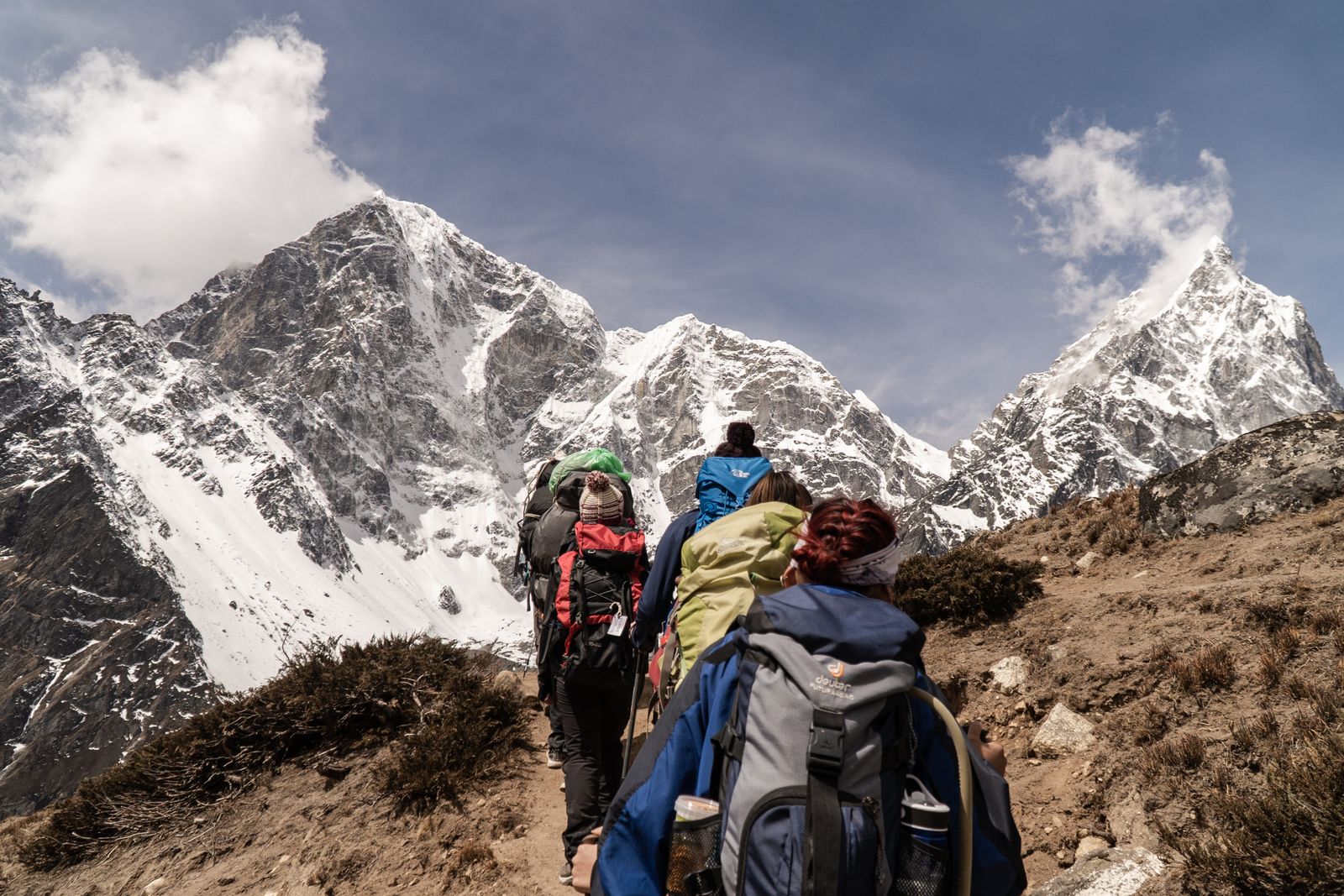 A hiker using trekking poles on a mountain trail