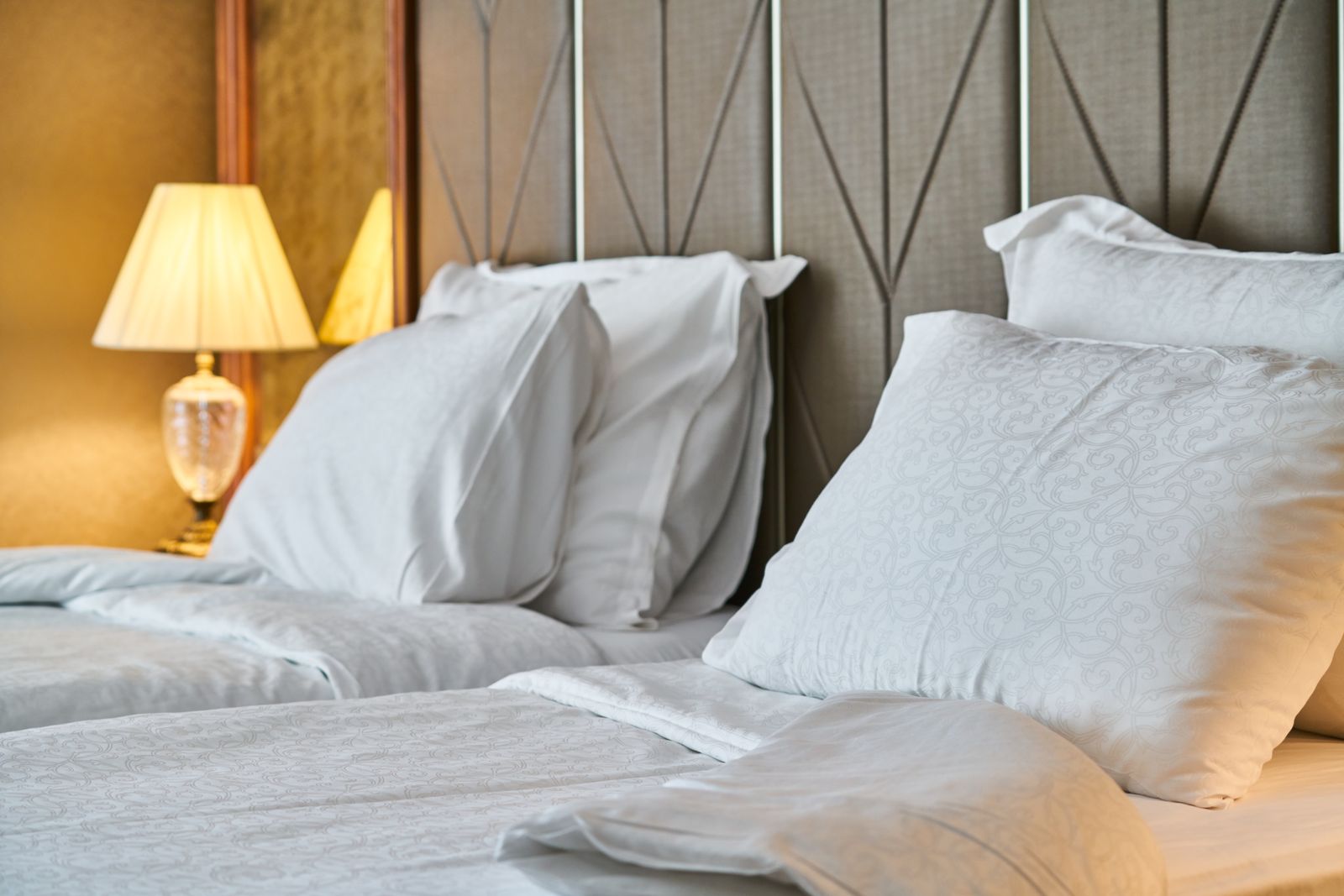 Neatly made bed with fresh white sheets in a bright bedroom