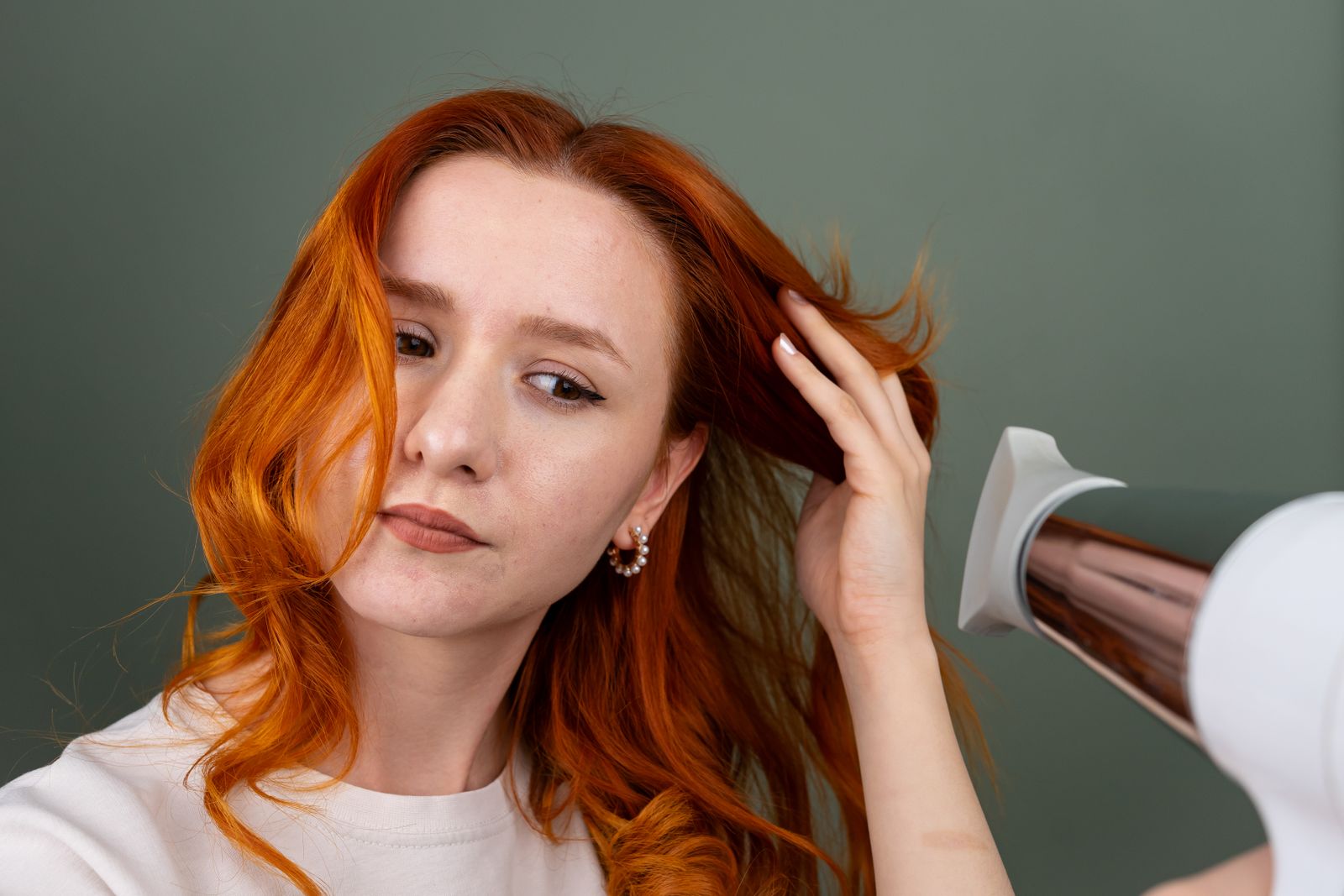 Woman blow-drying long hair with a modern high-speed hair dryer