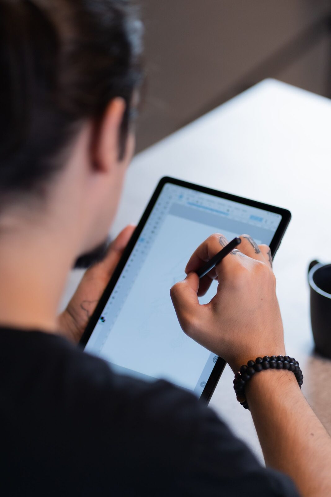 A person taking notes on a tablet with a stylus pen