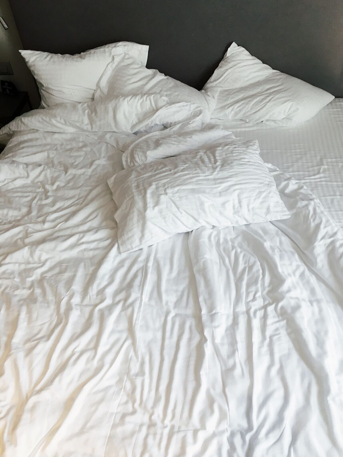 Soft silky bedding with a fluid drape folded on a bed