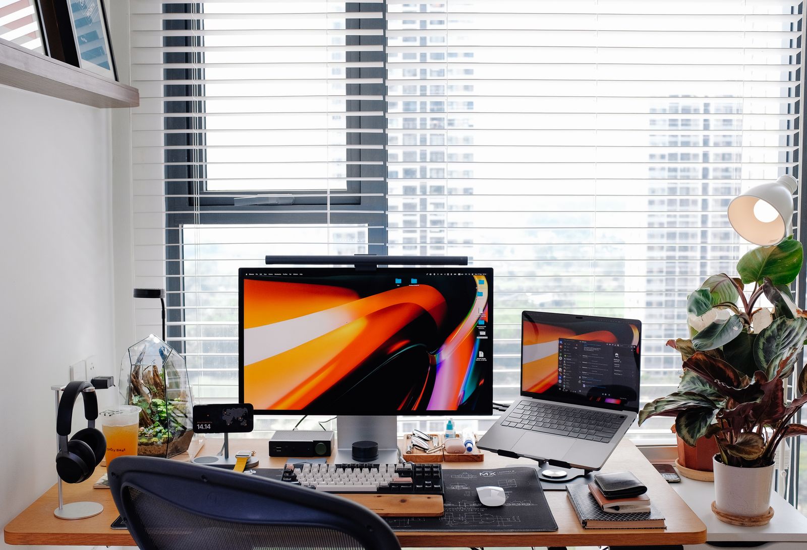 Modern monitor on a tidy home office desk beside a laptop