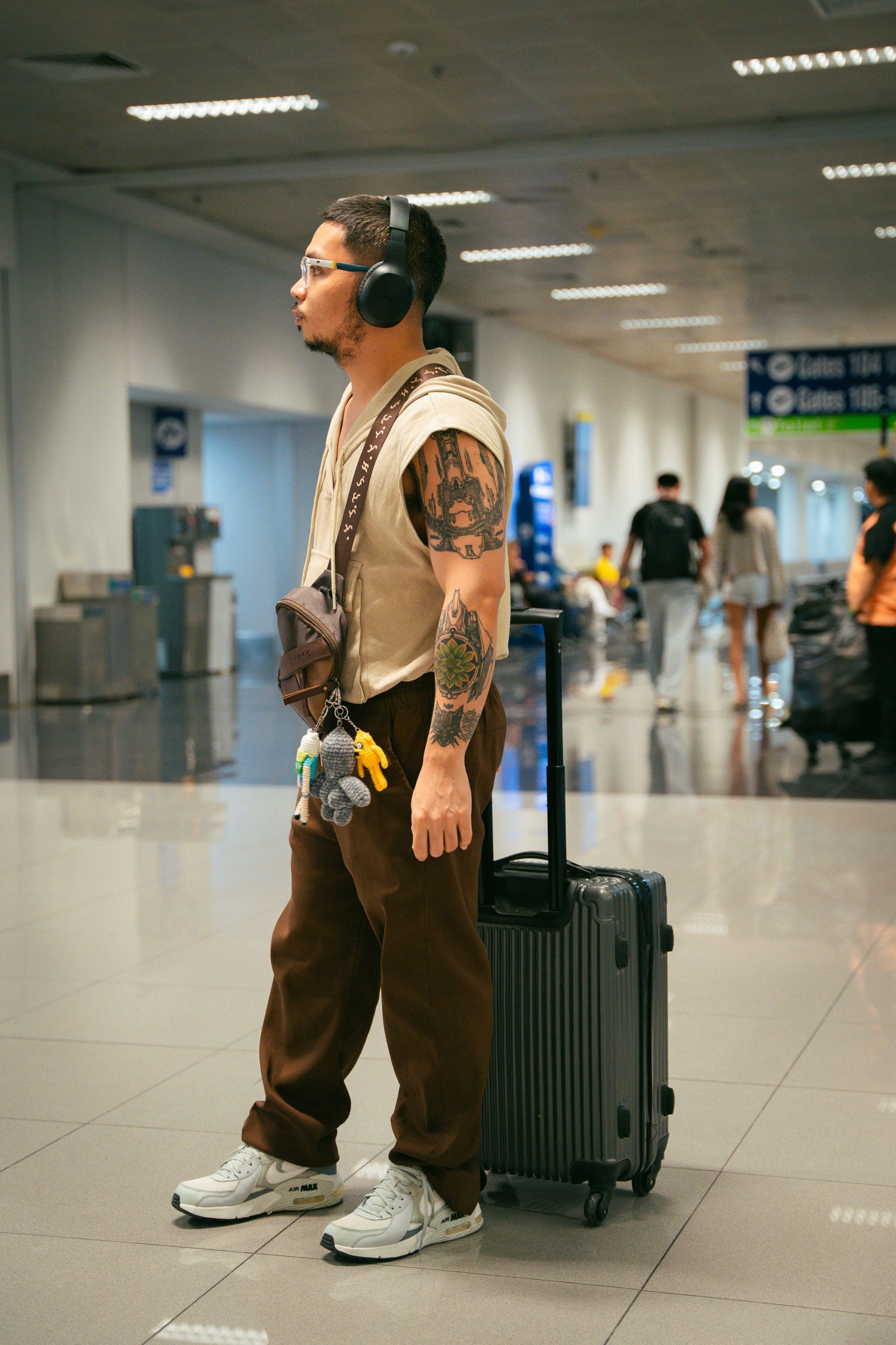 Man walking with carry-on luggage through an airport terminal