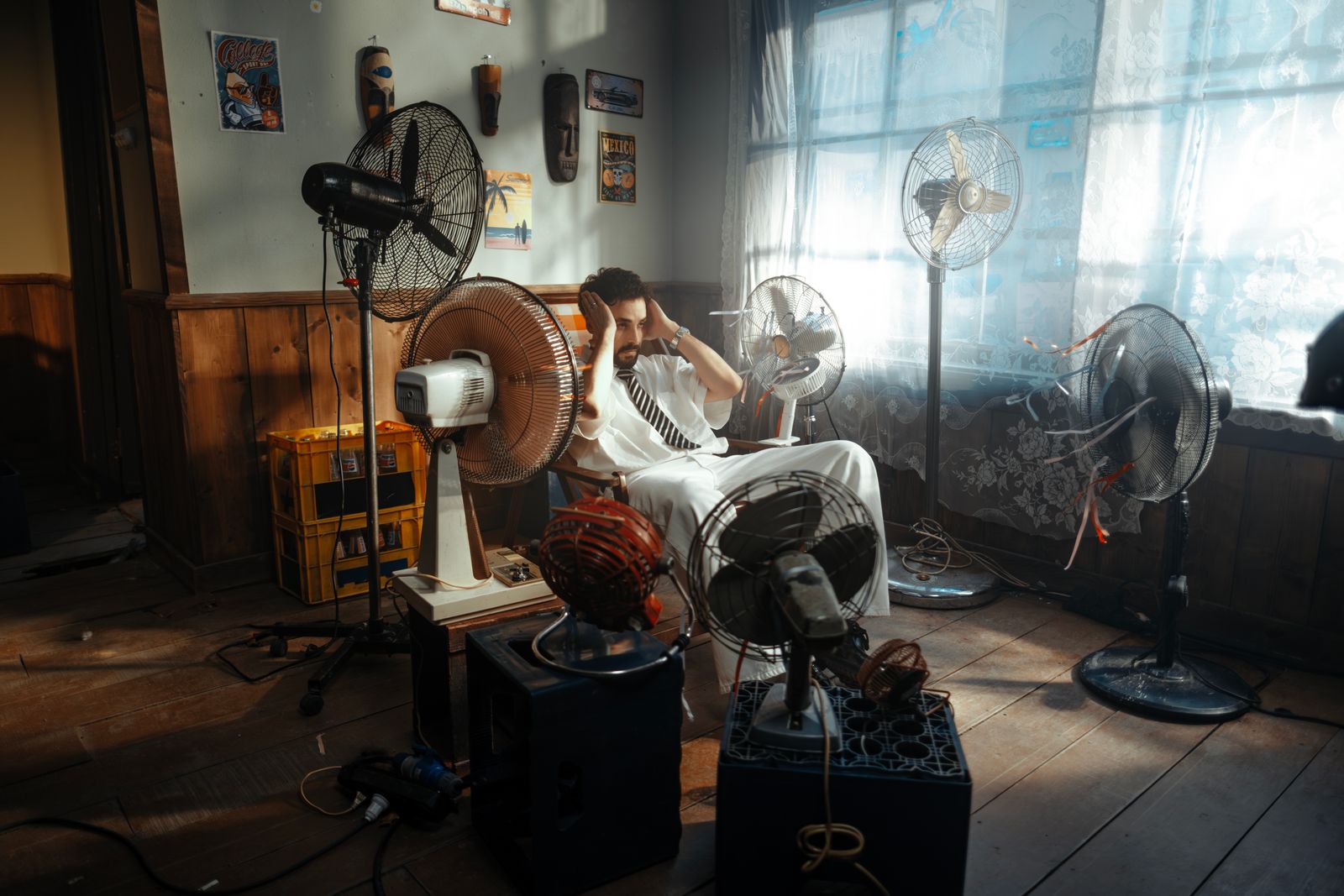 Pedestal fan with a caged blade on a pole in an open living room