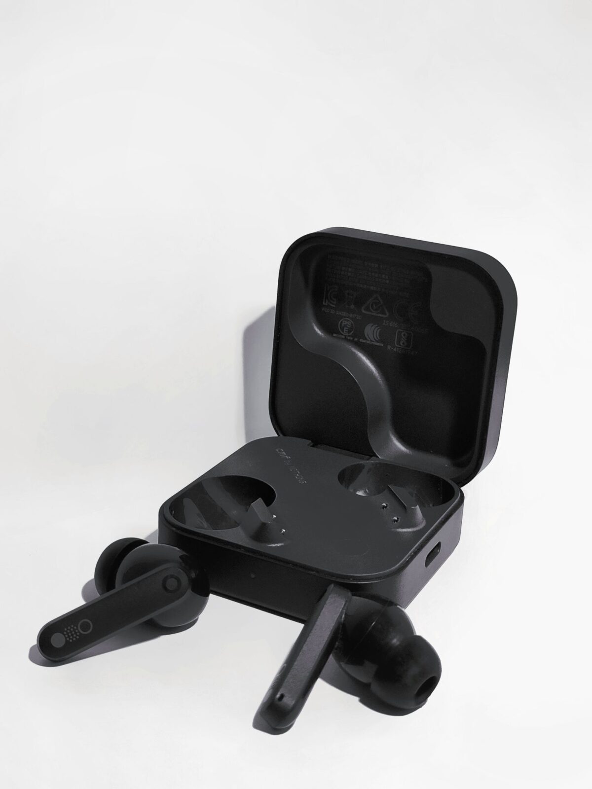 Minimalist black wireless earbuds with charging case