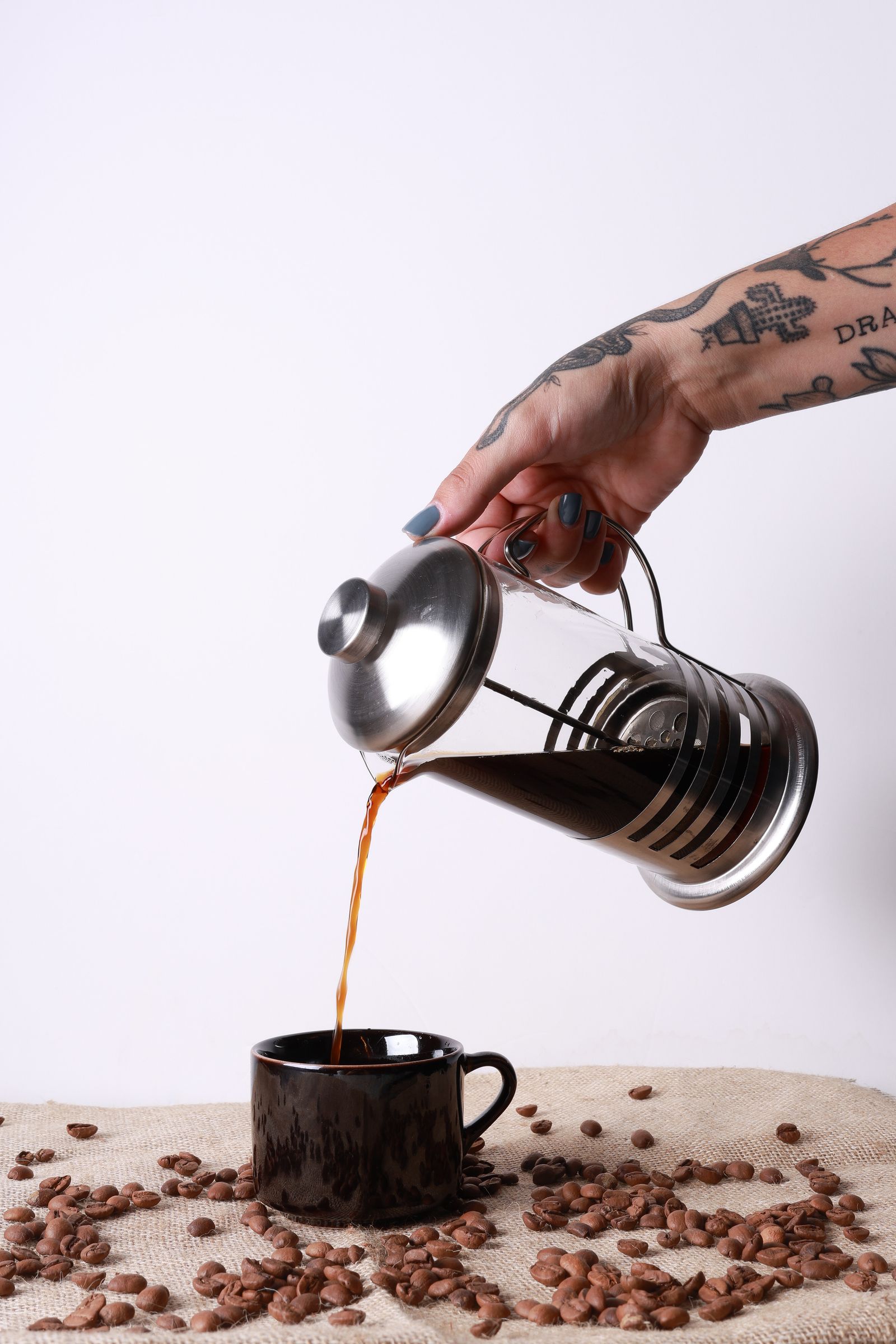 Coffee being poured from a French press into a cup