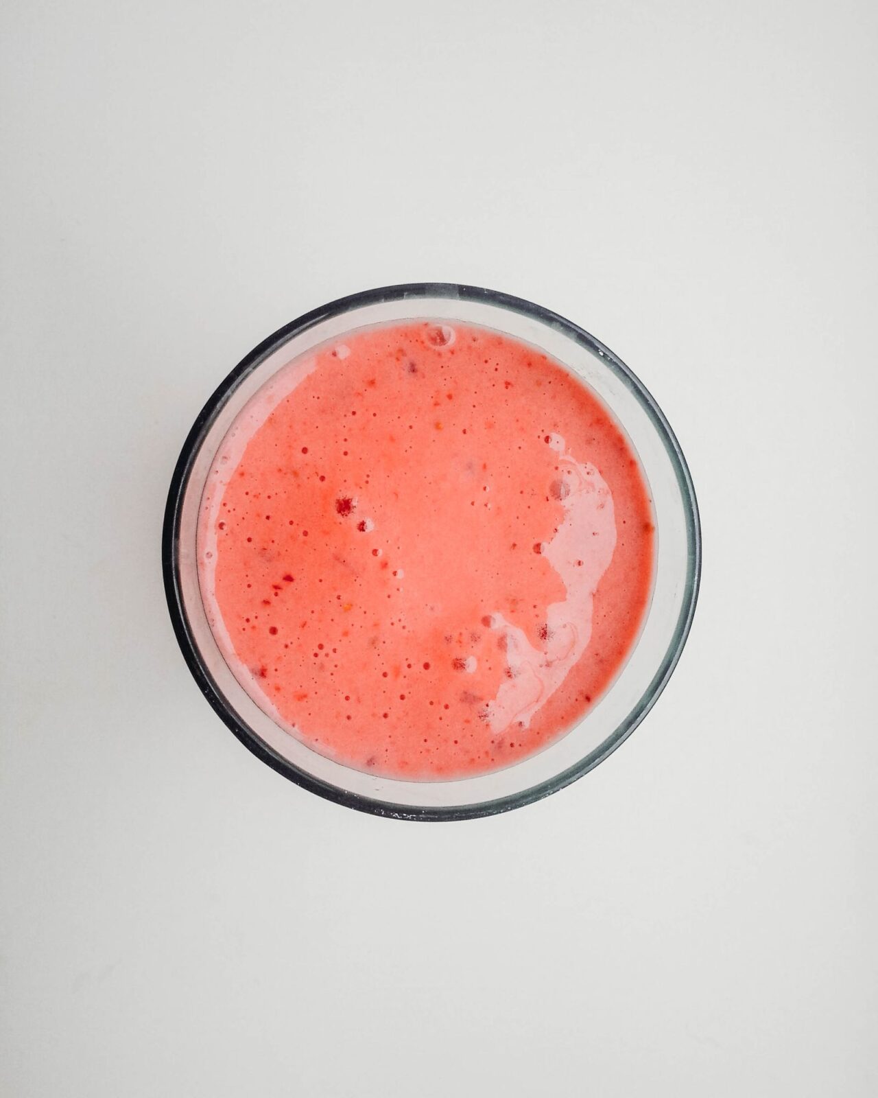 Meal replacement shake in a glass beside oats and a scoop of powder