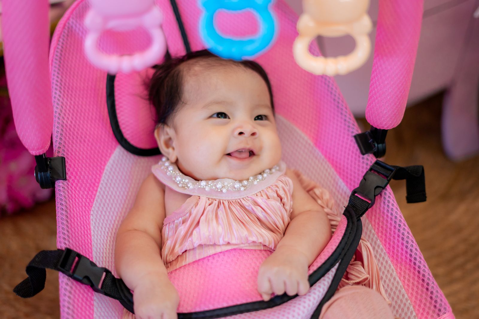 A baby resting in a powered baby swing