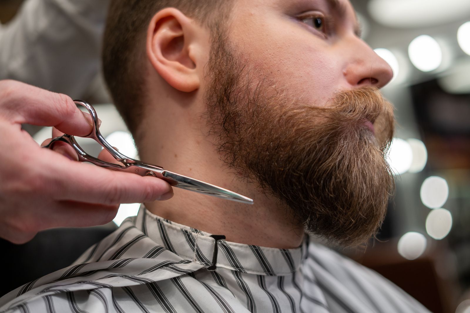 A man getting his beard trimmed and shaped