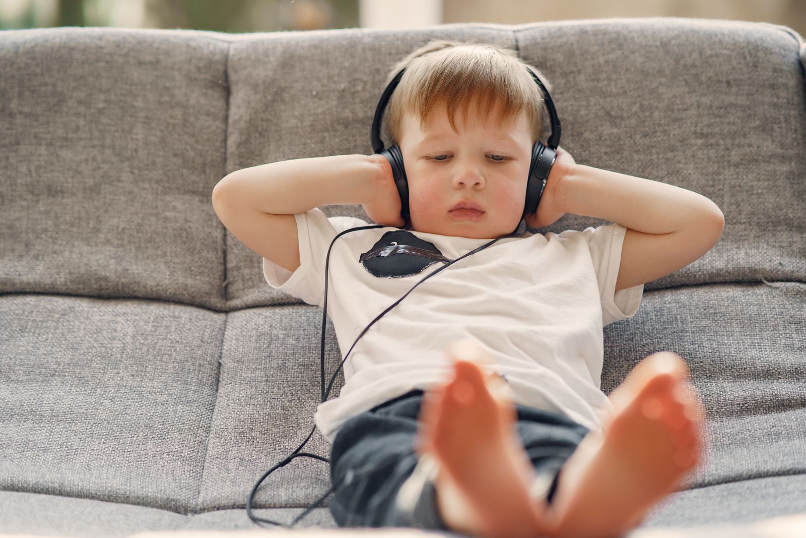 A happy child wearing over-ear headphones