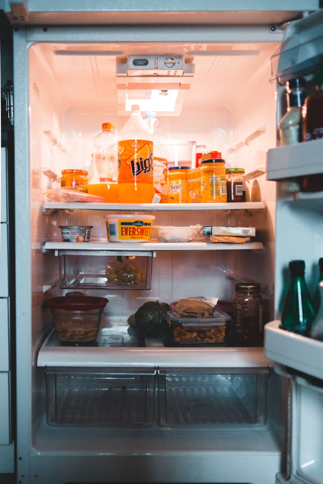 Open compact refrigerator stocked with drinks and food