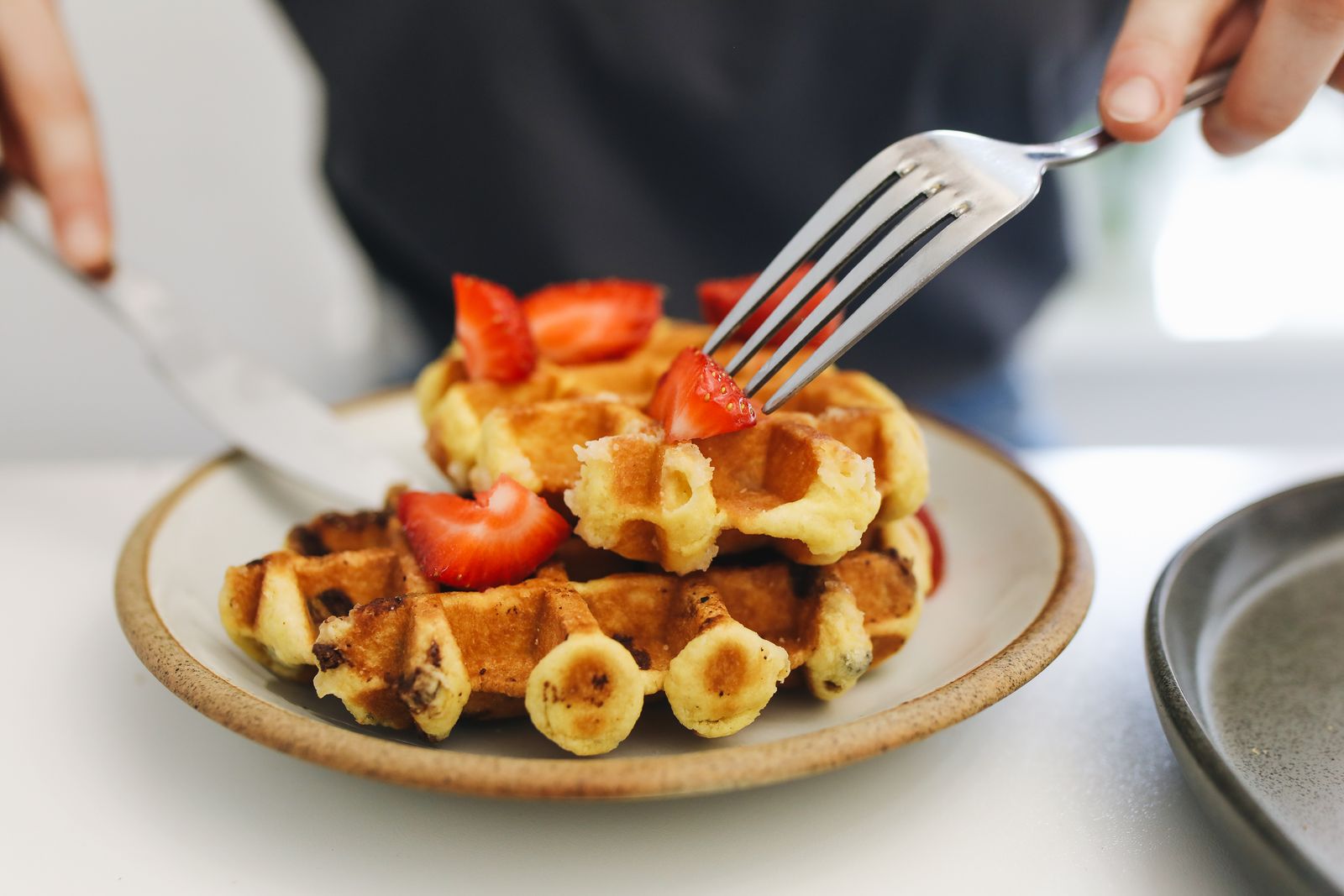 Fresh waffles topped with berries on a white plate