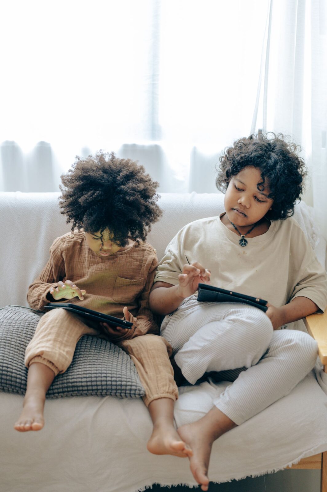Young child using a tablet on a couch at home
