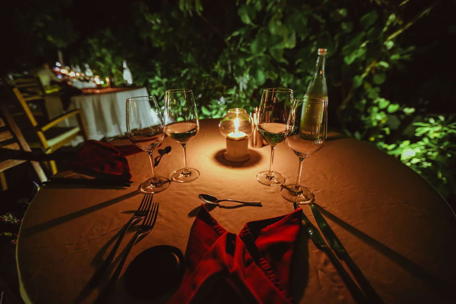 A glowing candle on an outdoor table at dusk
