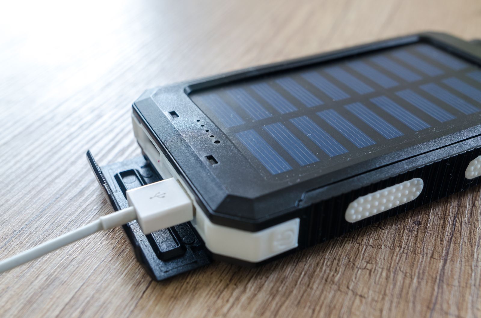 A portable power station charging from a solar panel at a campsite