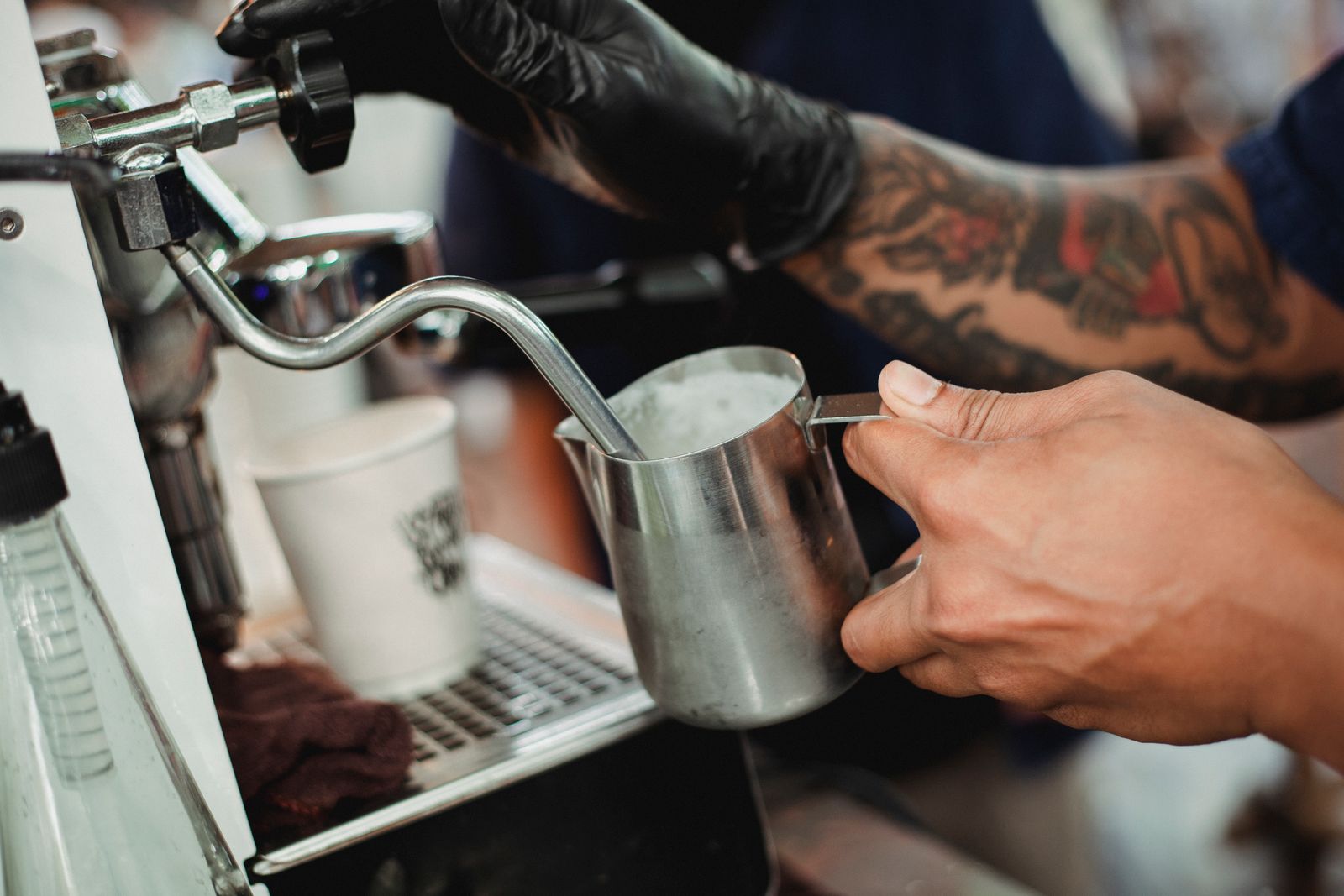 Barista texturing milk with a manual steam wand