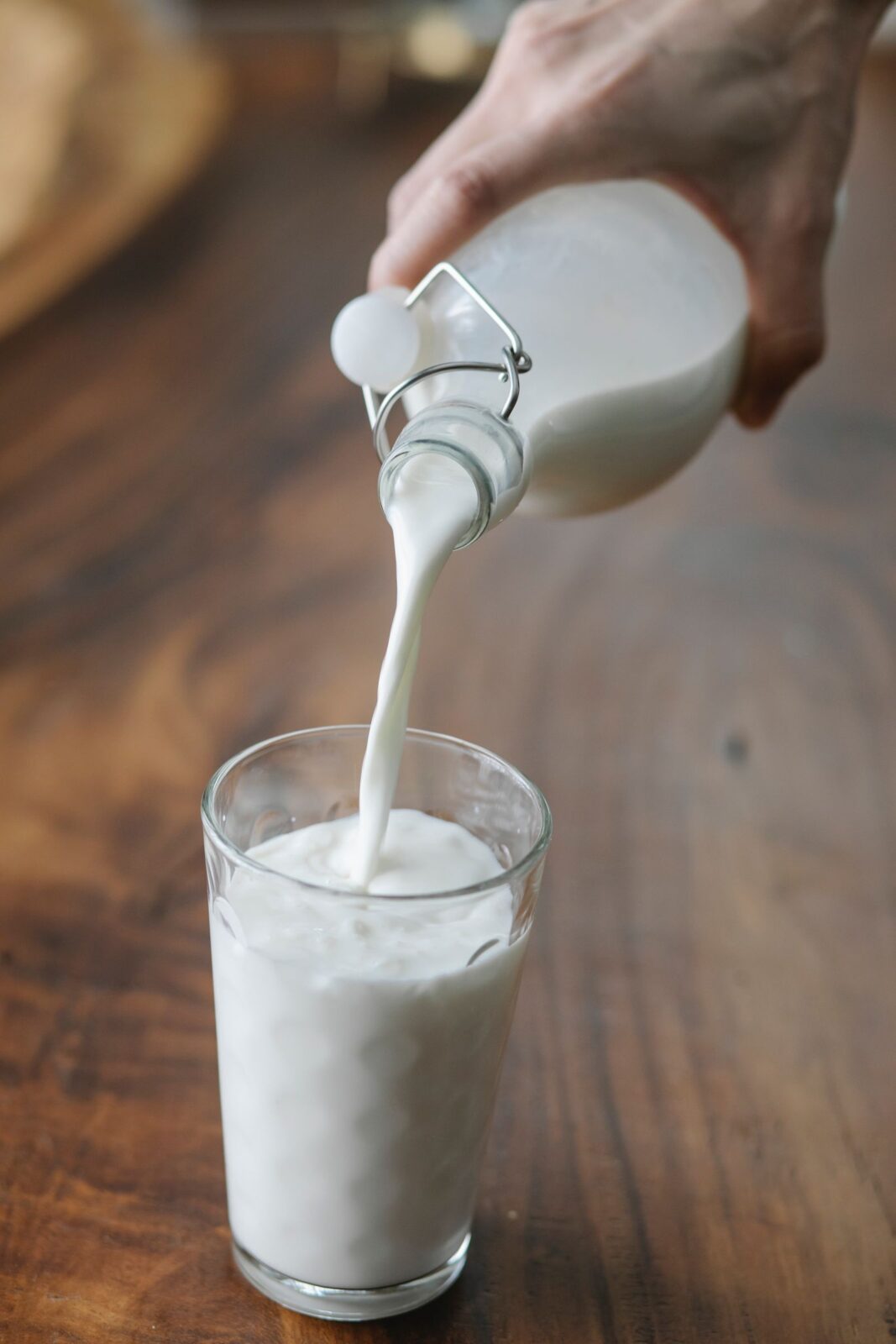 Clean protein shake being poured into a glass in a bright kitchen