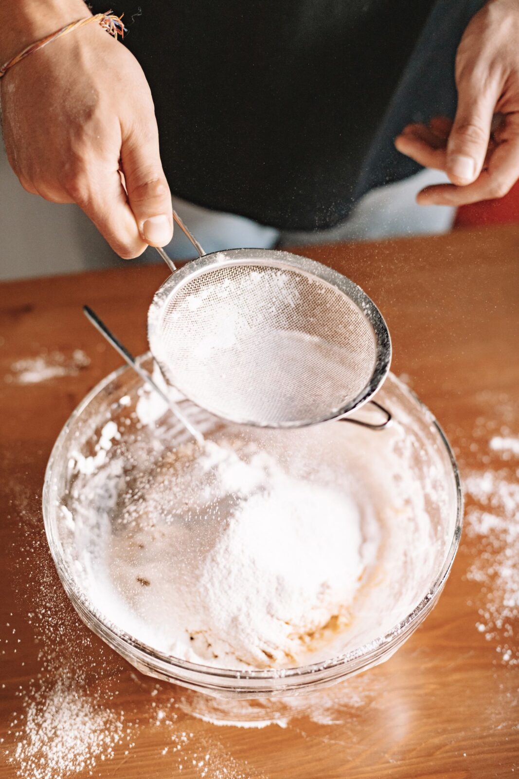 Scoop of protein powder next to a shaker bottle on a bright counter