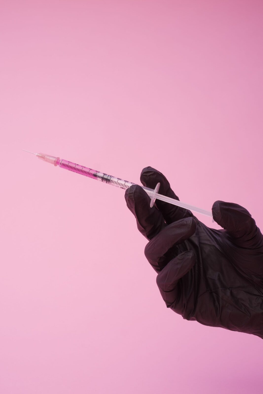 A generic injection pen beside a small stack of coins and money