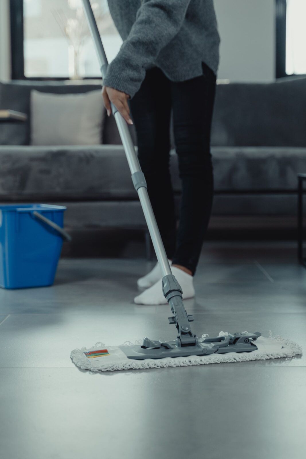 A person mopping a bright, clean tiled floor