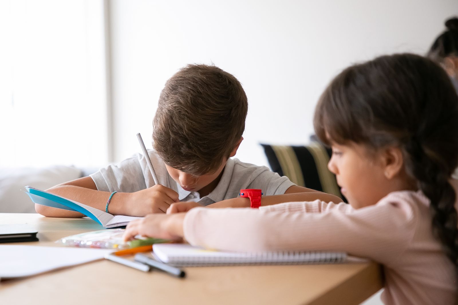 Children working through printed homework at a table