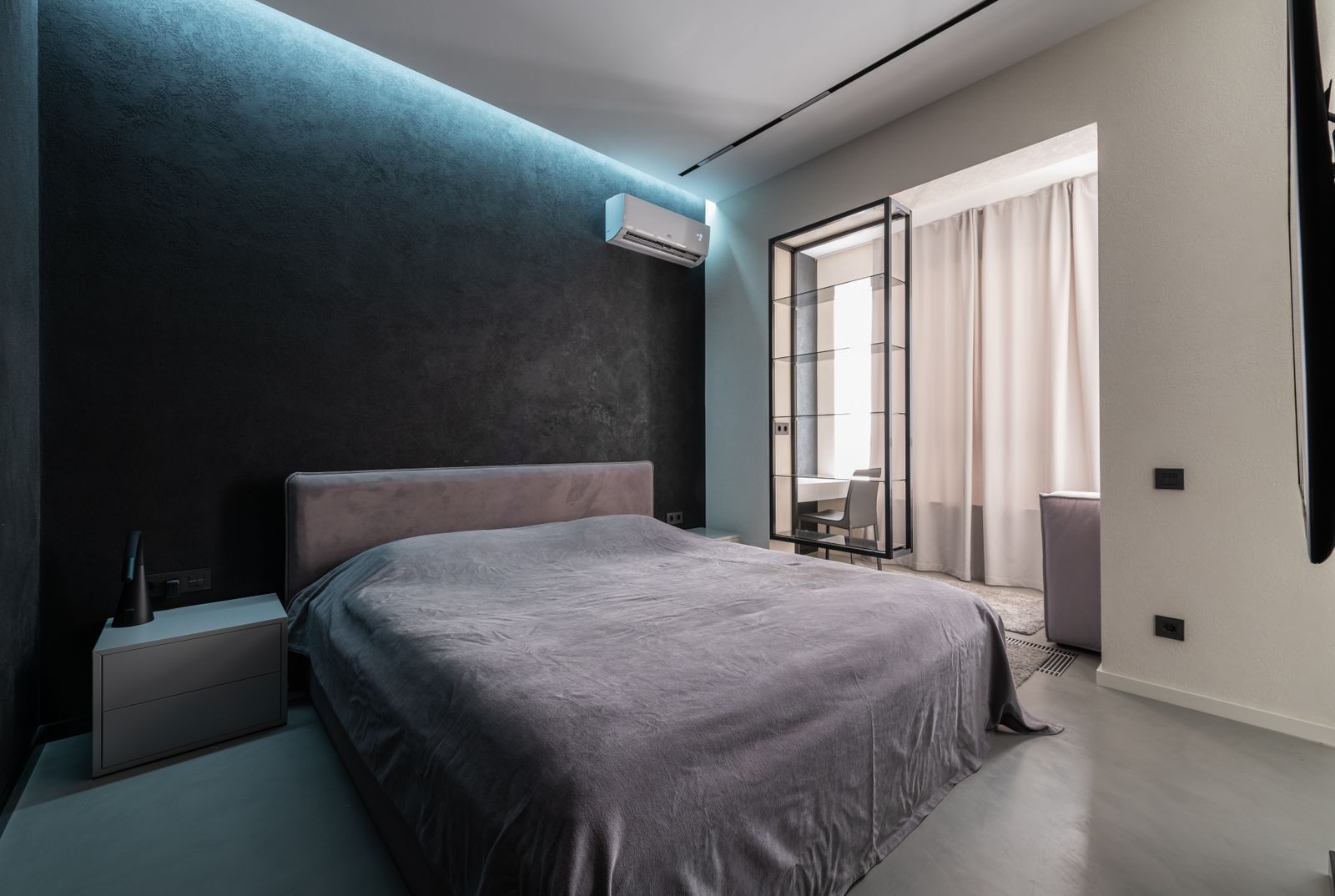 A made-up double-height air mattress in a bright guest room